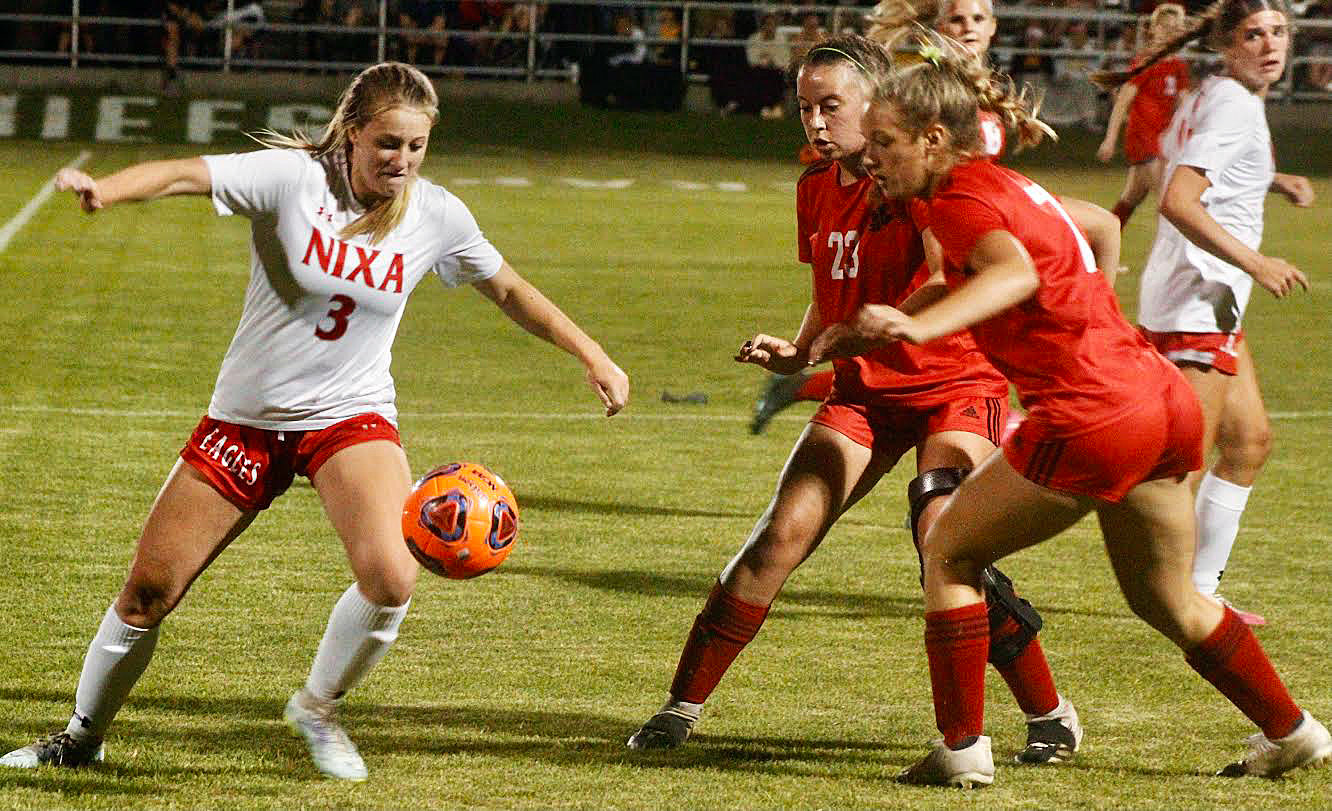 NIXA’S BELLA JOHNSON gets set to kick the ball downfield in front of Ozark’s Natalie Morgan and Clarice Wheeler.