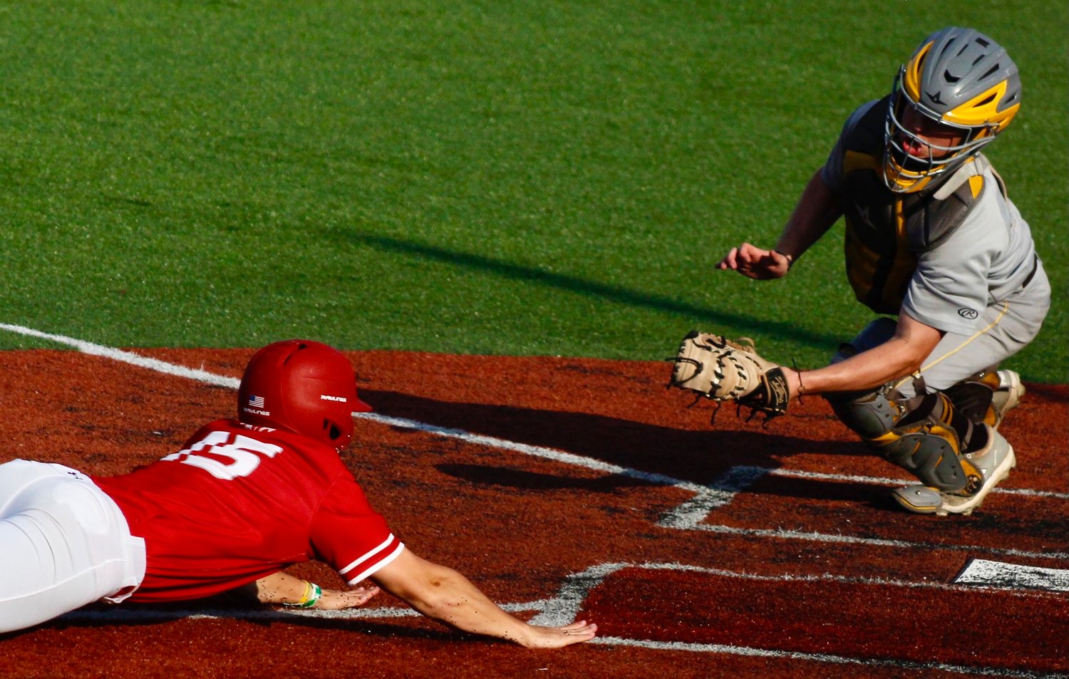 NIXA'S COLLIN USSERY slides toward a Kickapoo tag at the plate in the teams' matchup Thursday.