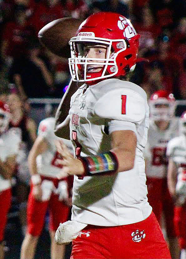 OZARK'S BRADY DODD runs out of the pocket while eyeing a wide receiver.