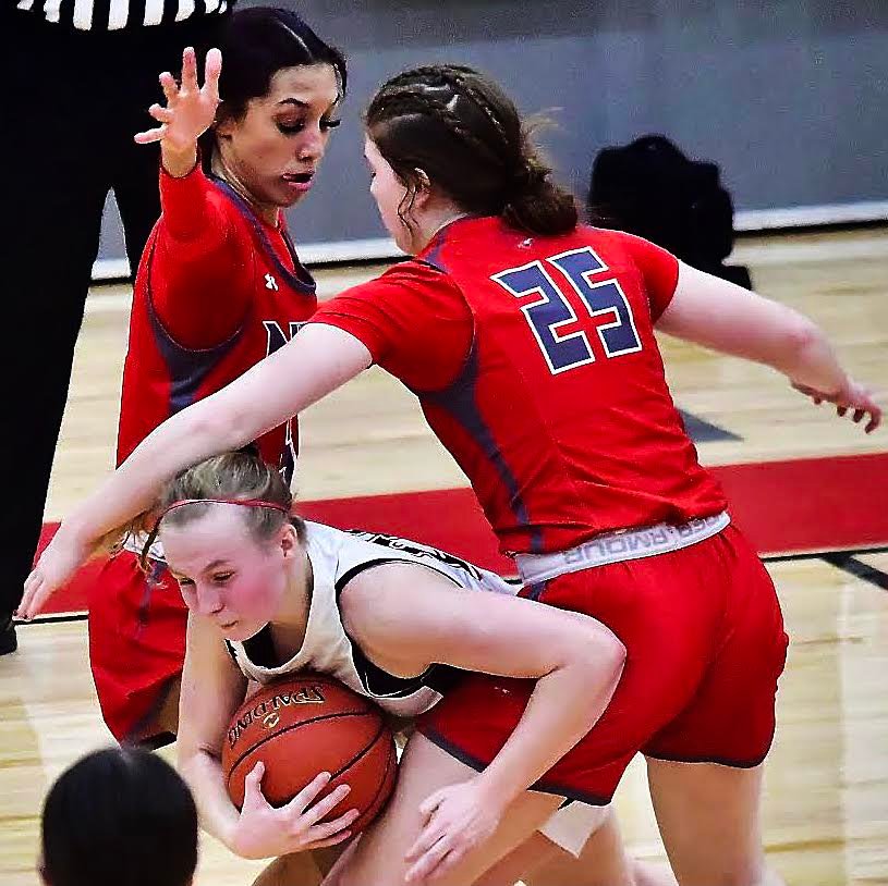 OZARK'S MOLLY RUSHING goes under the arms of Nixa players.