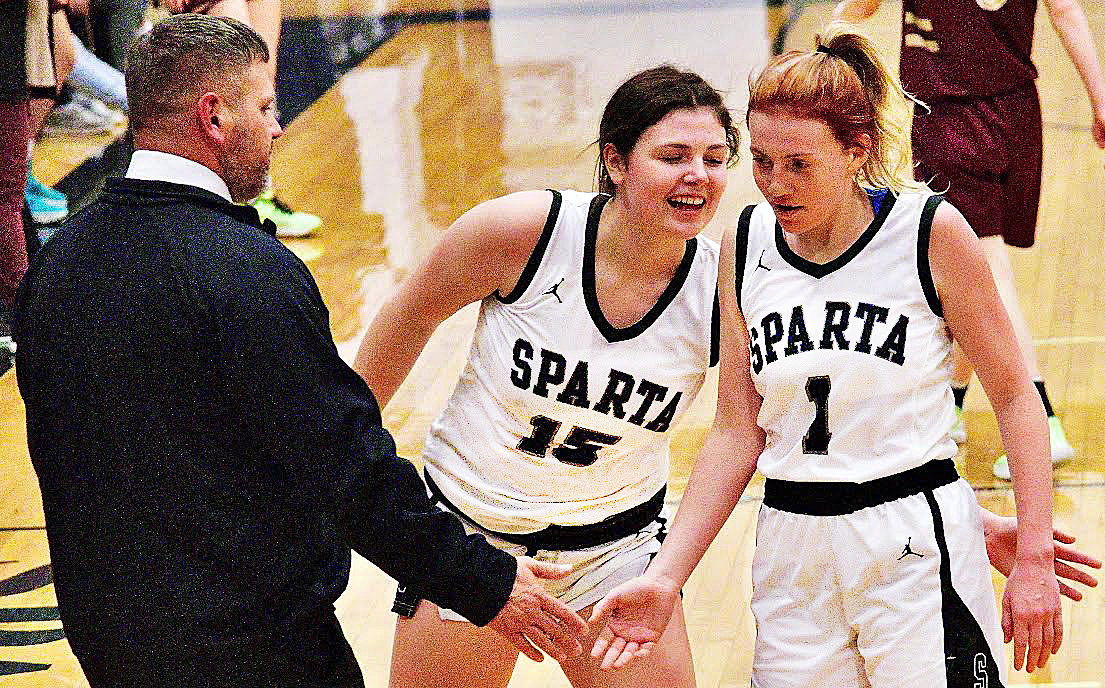 SPARTA'S MYA FULTON receives congrats from coach Josh Loveland and teammate Amree Youngmon following one of her four 3-pointers Tuesday.