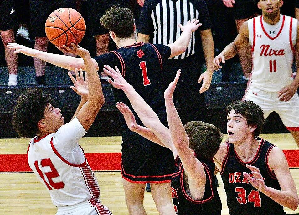 NIXA'S COREY KEMP shoots for two of his 15 points in Wednesday's Class 6 District 5 first-round game at Ozark.