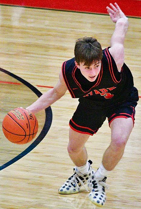 OZARK'S ETHAN SUTHERLAND dribbles downcourt.