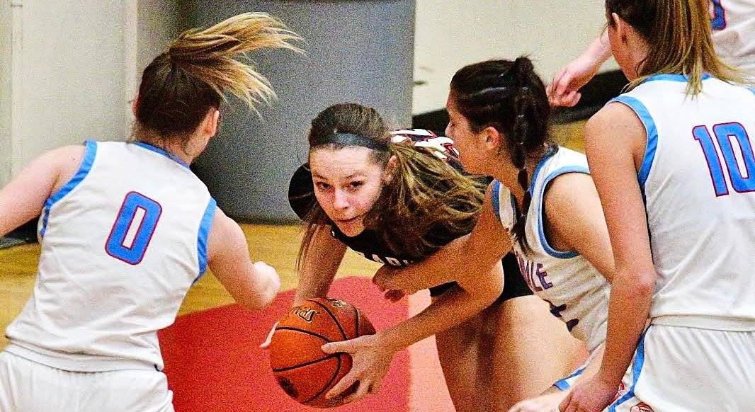 OZARK'S ALEXIS SOLOMAN draws a trio of defenders in Class 5 District 6 action Thursday.