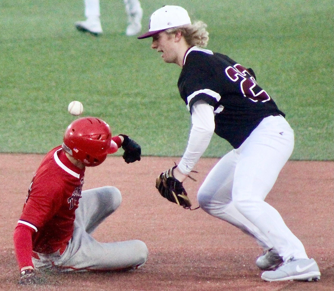 OZARK'S BROCK DODD slides into second base as a Rogersville infielder loses control of the ball. Dodd was called out on the play.