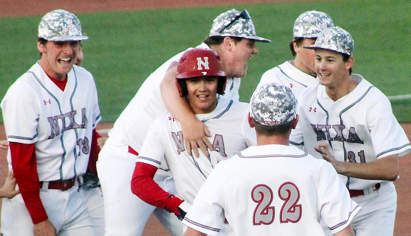 NIXA'S WYATT VINCENT is mobbed by teammates after the Ealges' 8-7 win Thursday.