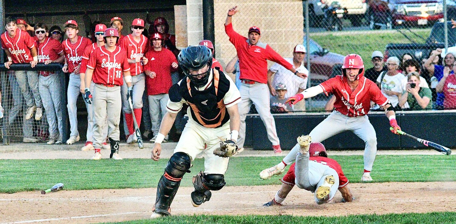 NIXA'S RYLAN MICHEL slides safely across home plate in the Eagles' District win at Republic.