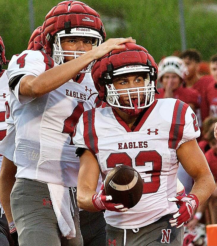 NIXA'S MALACHI RIDER received a pat on the helmet from teammate Nate Uber after a touchdown run.