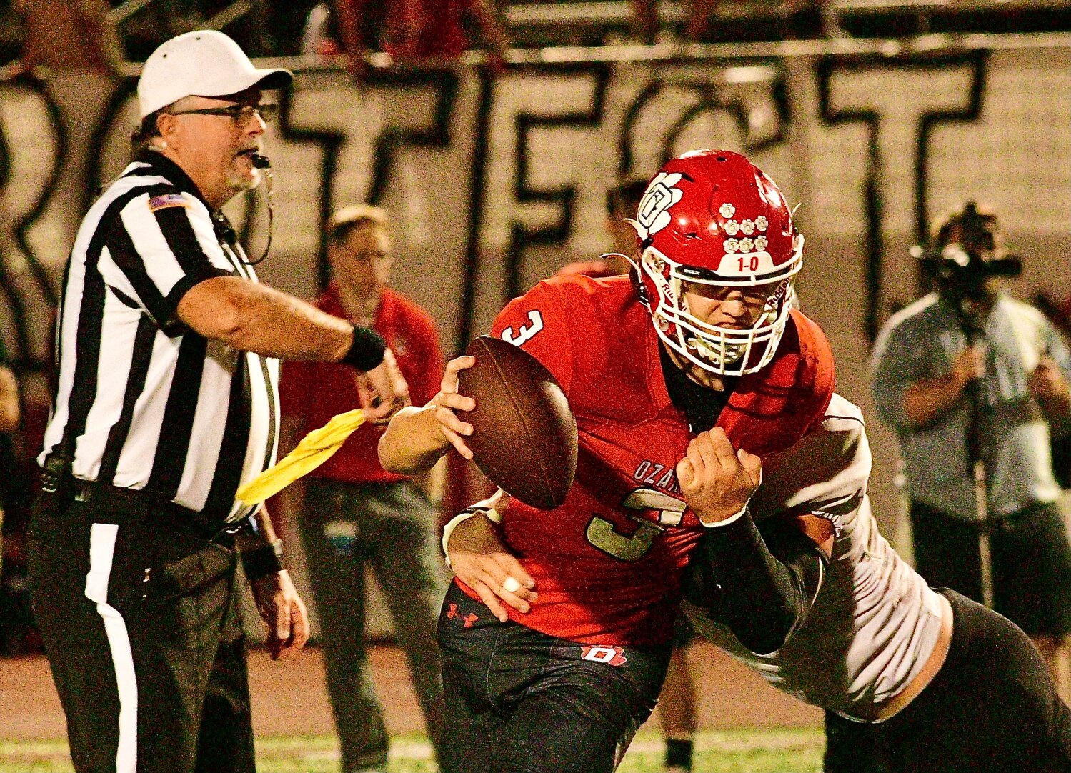OZARK'S PEYTON RUSSELL tries to escape from a Willard defender as a referee throws a flag.