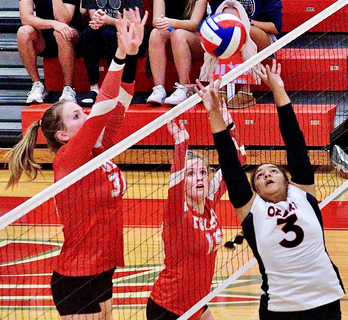 OZARK'S REECE COOK sets at the net Tuesday in front of Nixa's Ava Owens and Amelia White.