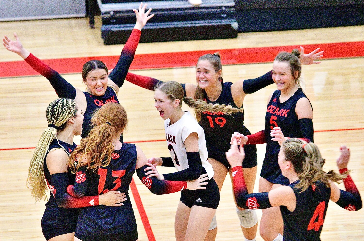 OZARK'S MACY HUMBLE is surrounded by teammates after the Lady Tigers swept Carl Junction on Thursday.