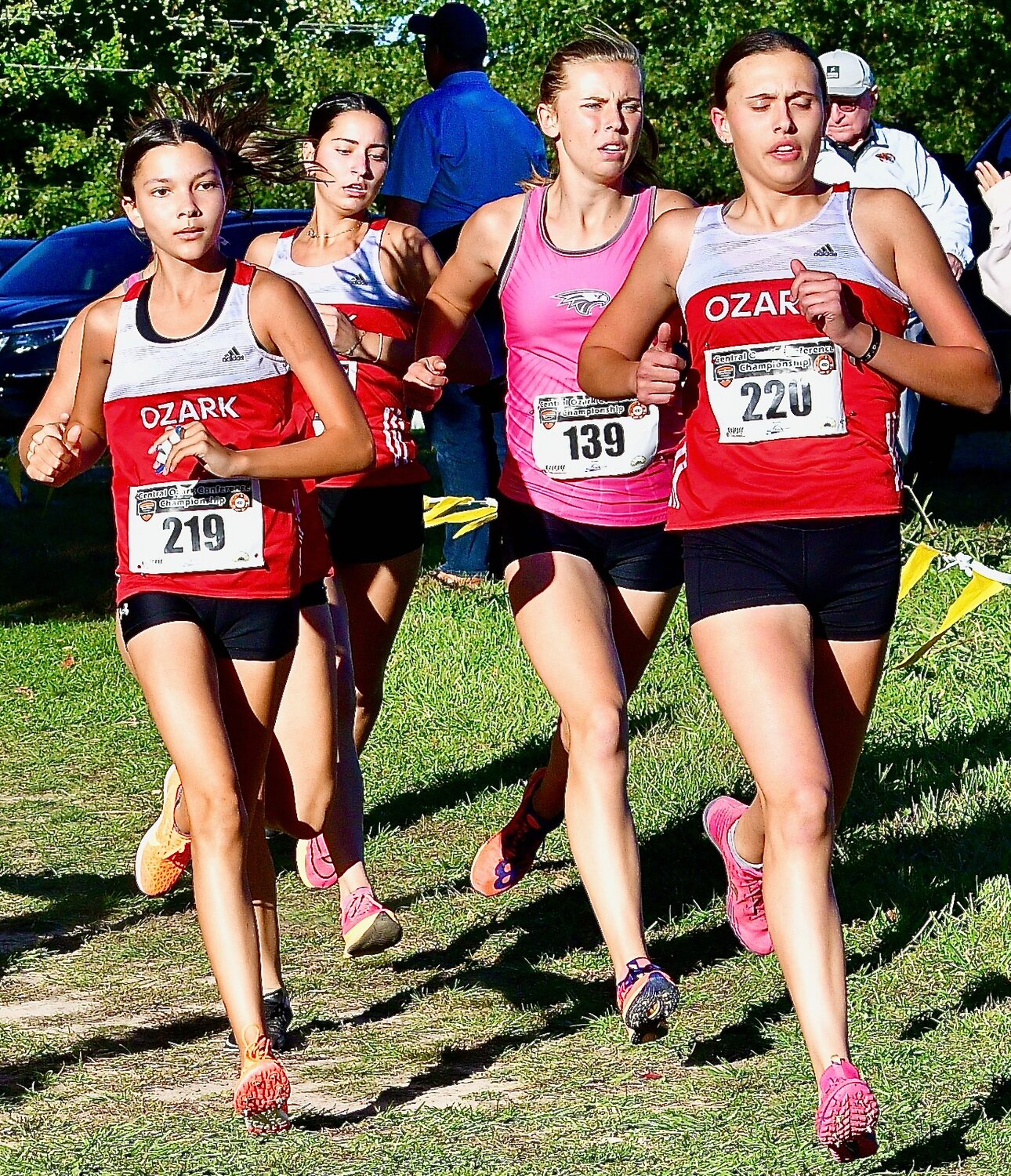 OZARK'S ELSIE ESTES, left, races to a second-place finish at the COC Championships on Tuesday.