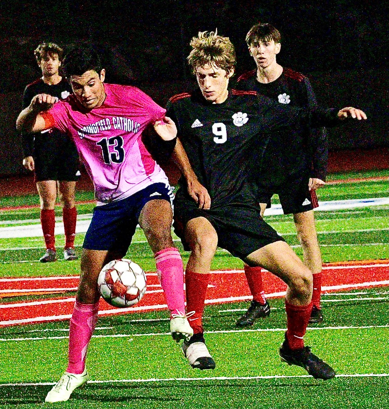 OZARK'S BRADY SCHUPP and a Springfield Catholic player battle for control of the ball.