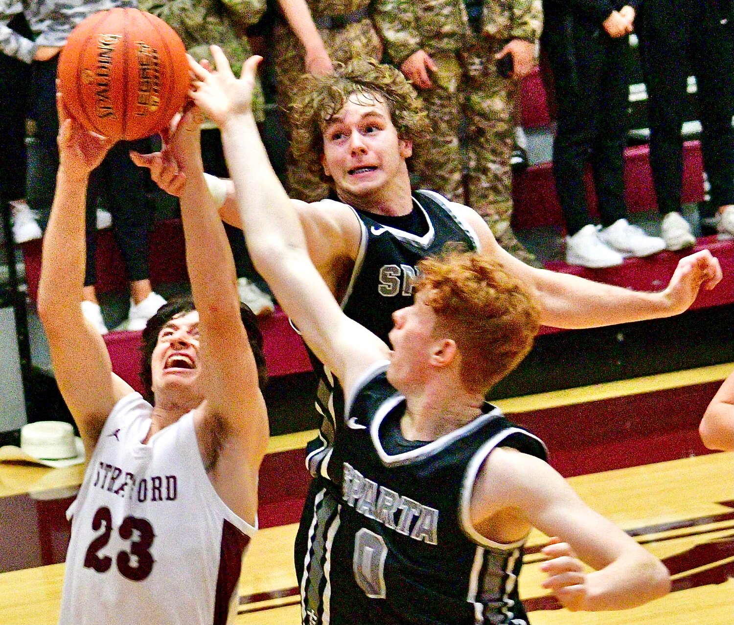 SPARTA'S JAKE LAFFERTY AND ROWDY BALL battle a Strafford player for a rebound.