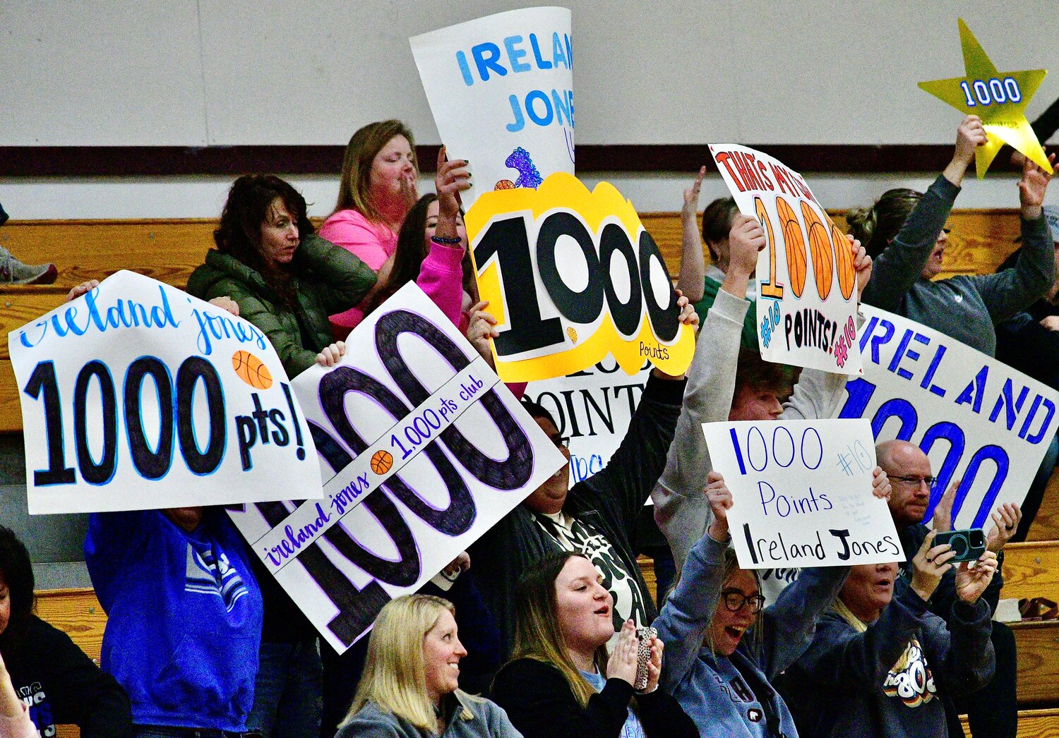 CLEVER FANS hold up posters celebrating Ireland Jones' 1,000th point.