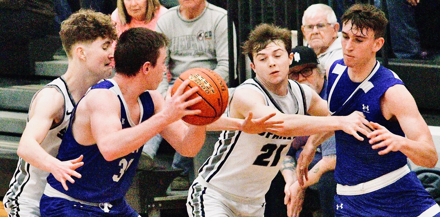 SPARTA'S MASON LETTERMAN defends in between two Hartville players.