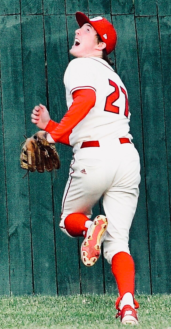 OZARK'S ETHAN BLANCHARD watches a Helias home run sail over the left-field fence.