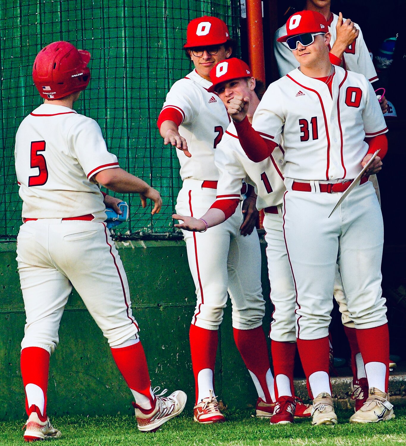 OZARK'S GAVIN MILLER is greeted by teammates after one of his three hits.