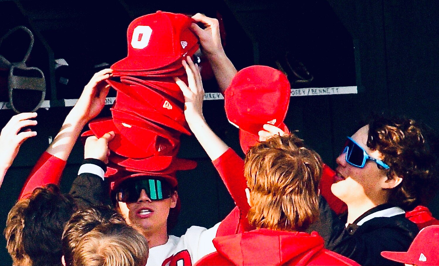 OZARK'S AIDAN DAVIS holds hats as teammates add to his stack.