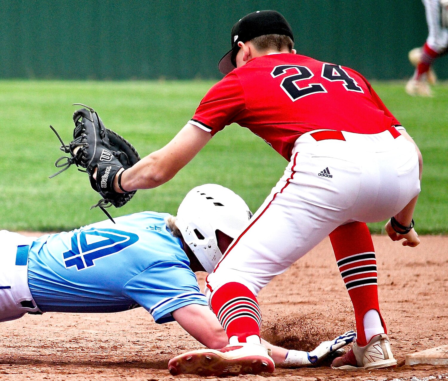 OZARK'S TRUMAN GRISSEL gets set to tag out a Liberty baserunner out at first base.
