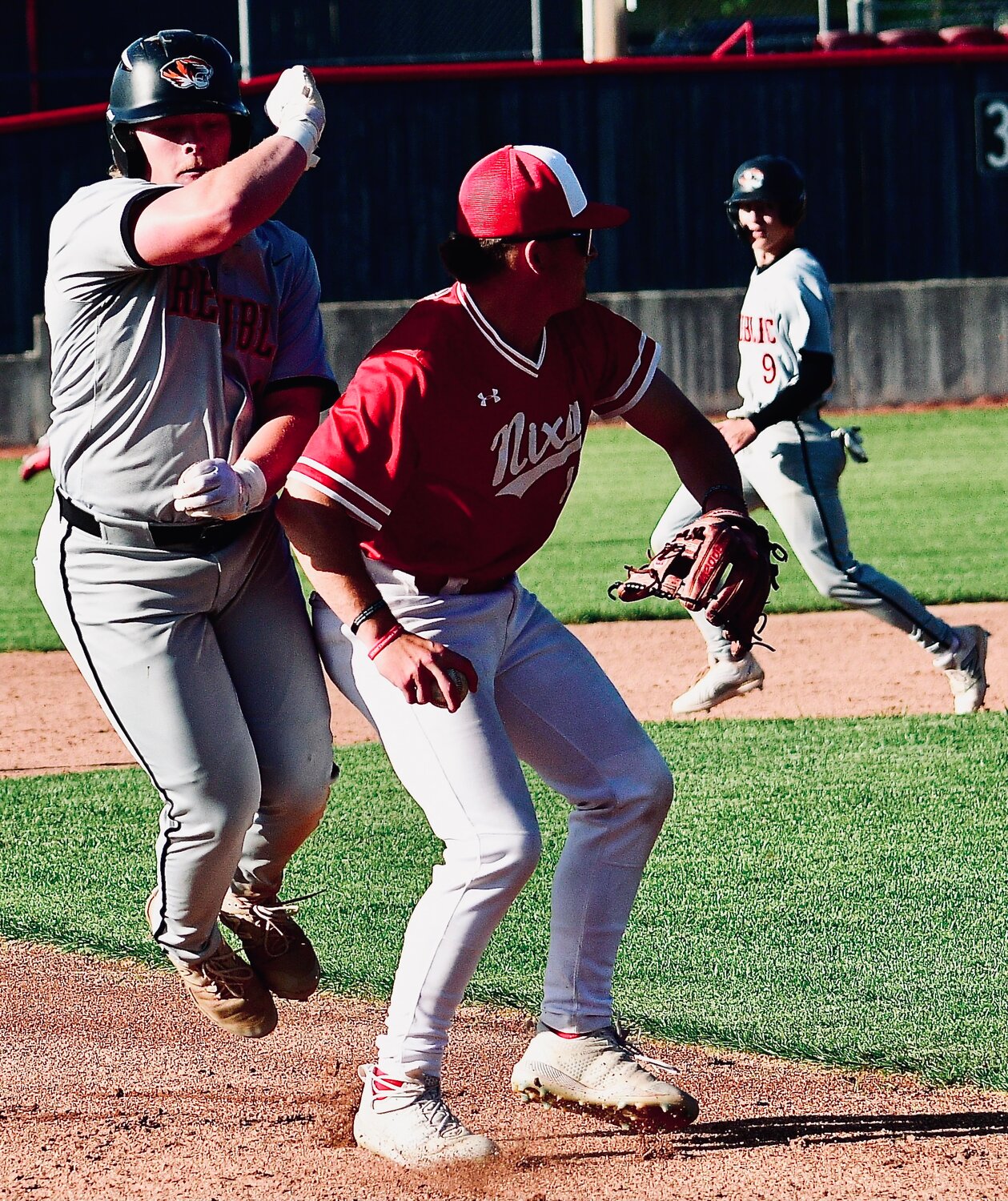 NIXA'S BRODEN MABE and a Republic runner try to avoid each other as Mabe makes a throw to first base.