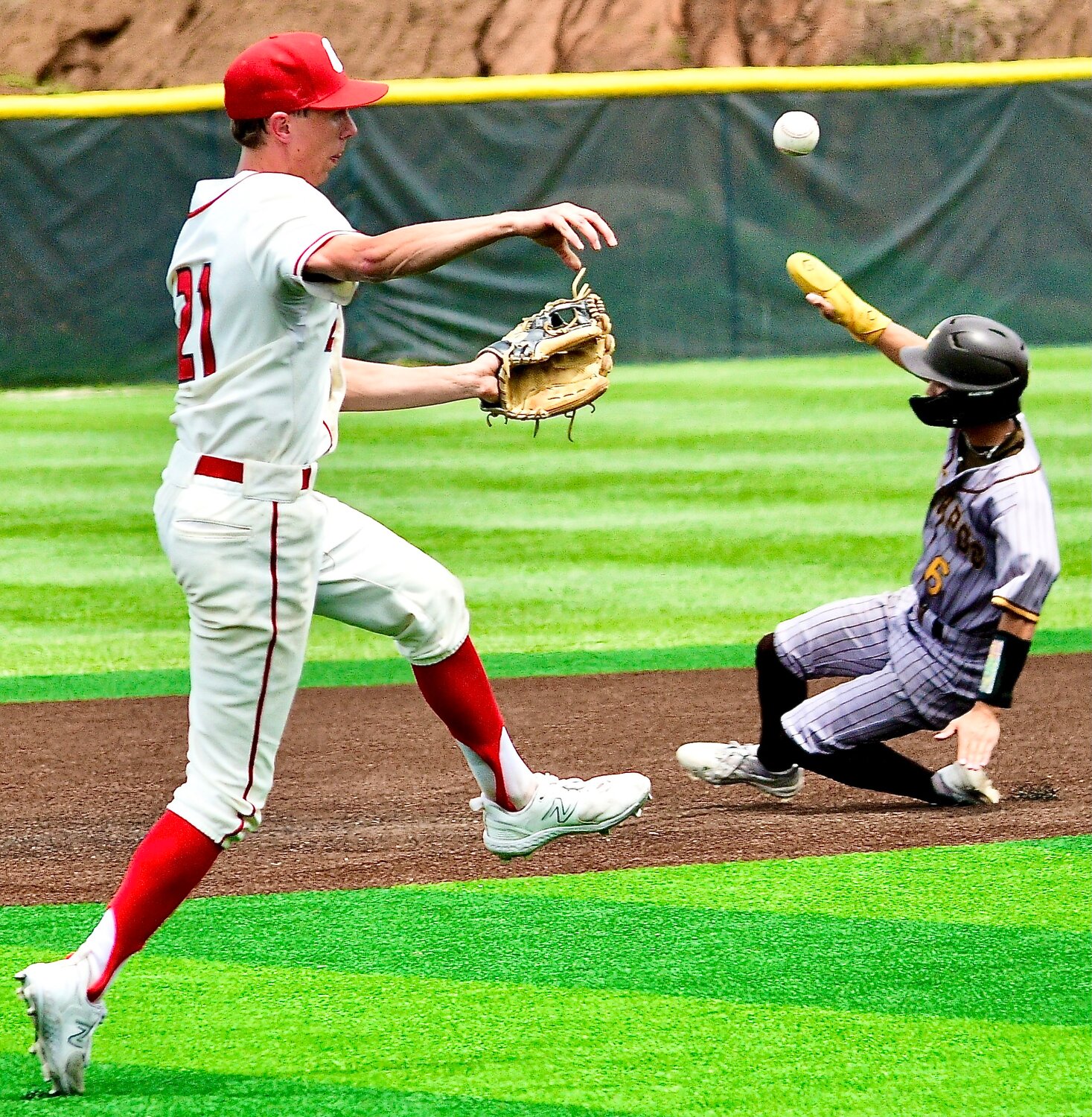 OZARK'S ALEX NIMMO makes a throw to first base as a Kickapoo runner slides at second base.