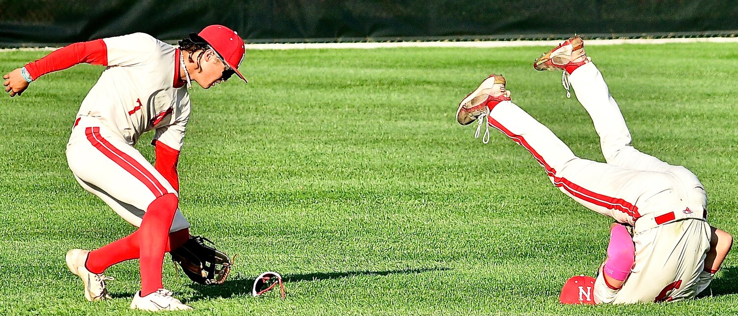 NIXA'S WYATT VINCENT scoops up teammate Caeden Cloud's sunglasses after Cloud made a leaping catch.