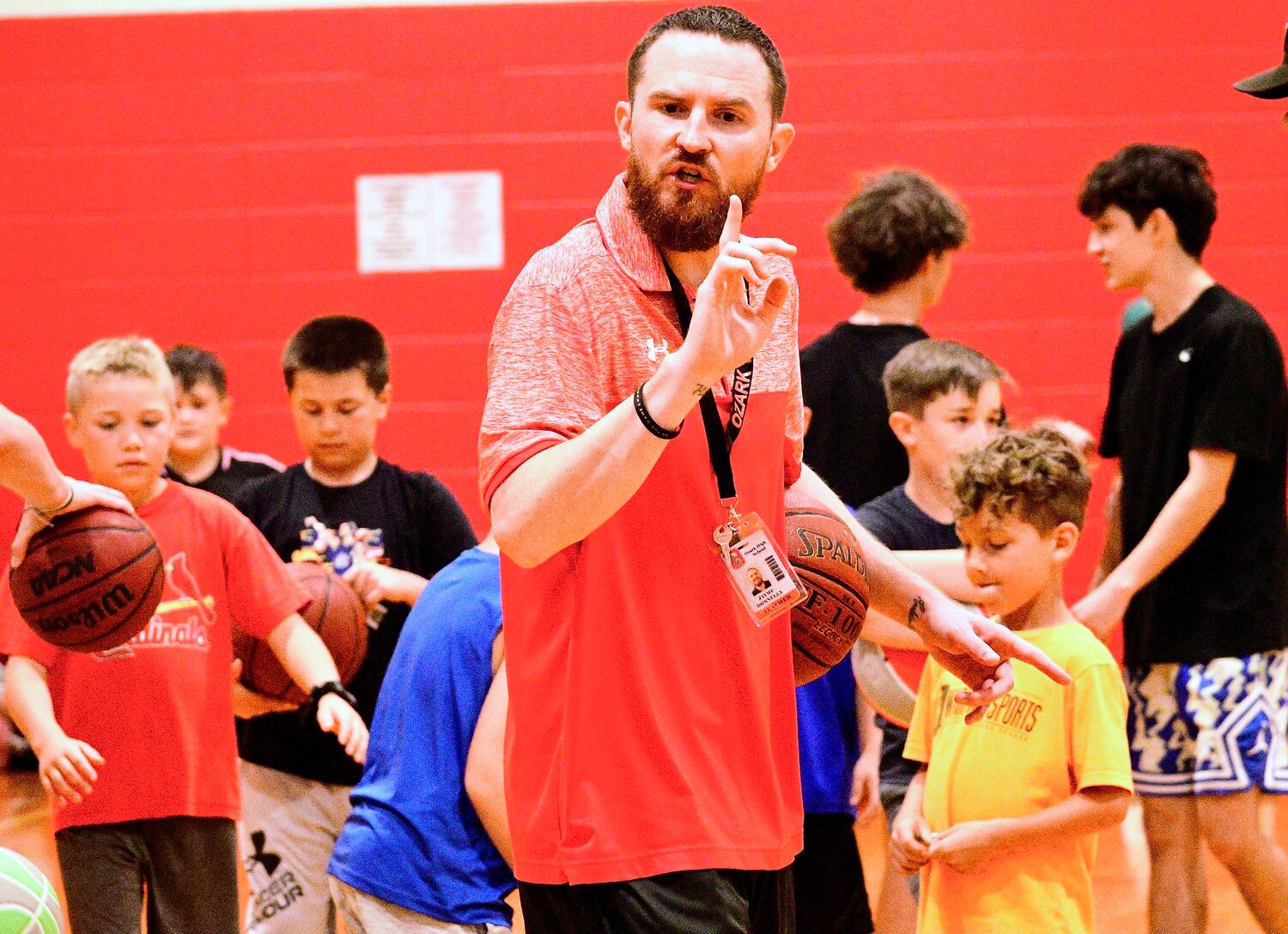 OZARK COACH JAYME DONNELLY gives instructions to players during the Tigers' summer camp last week.