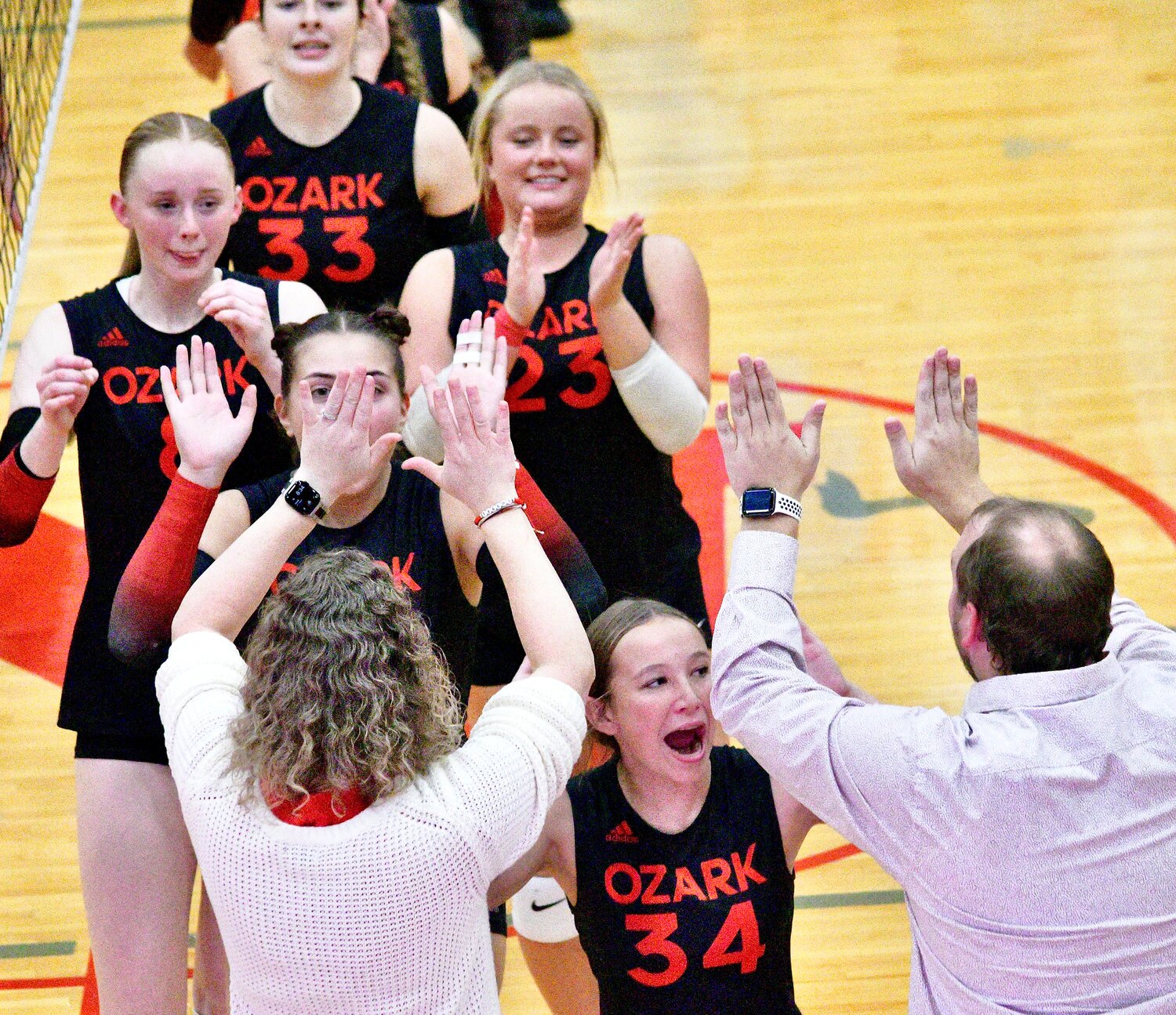 OZARK'S ANNA ESSICK exchanges high-fives with Lady Tigers coaches.