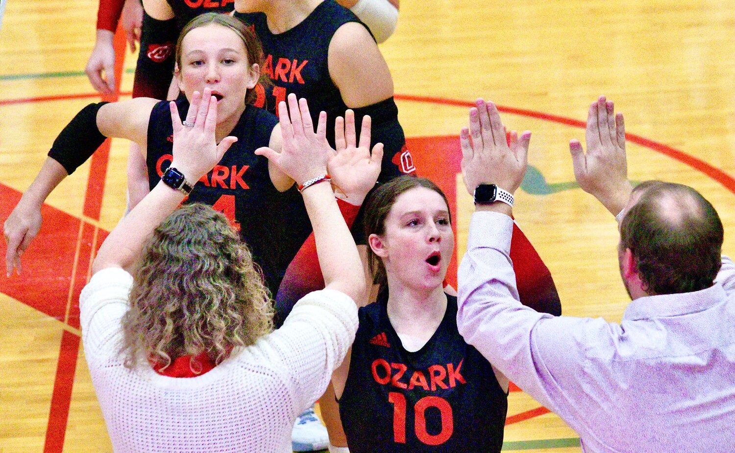 OZARK'S JANELLE SPOHN receives high-fives from coaches.