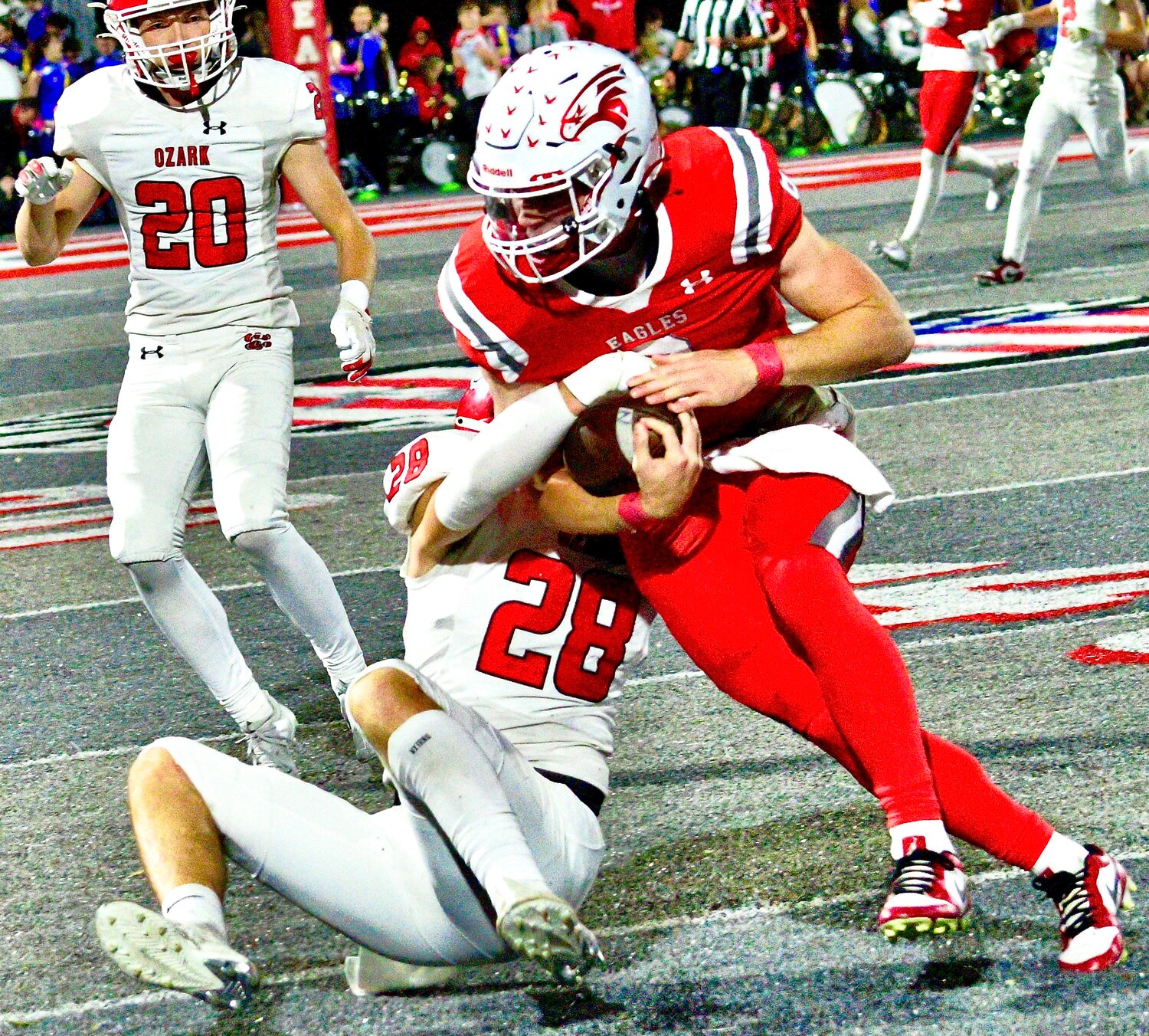 OZARK'S ADAM MCKNIGHT keeps a tight grip on the pigskin while tackled by Ozark's Ethan Charndler.