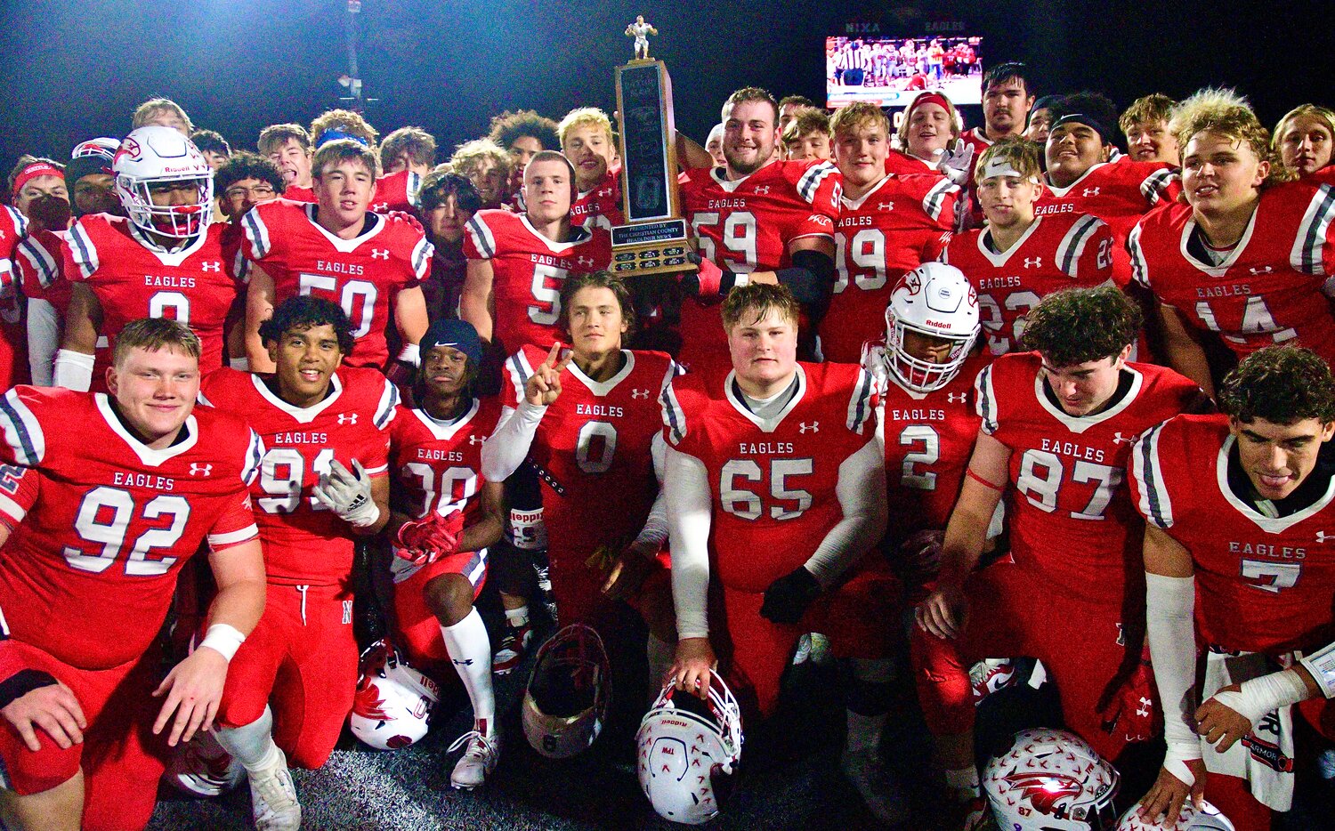 NIXA PLAYERS pose with the Backyard Brawl trophy.