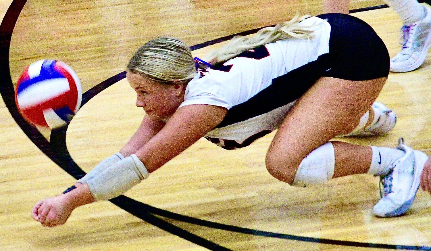 OZARK'S ALEXIS ANDELA hits the floor to return a serve.