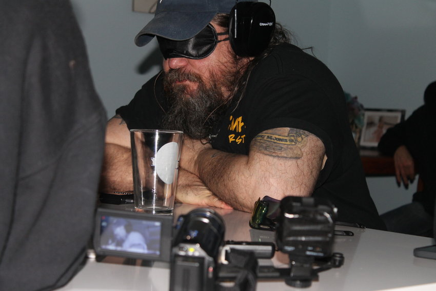 Jones listens intently for communications through the “spirit box” during an investigation in Jackson. Others in the room ask questions, and whoever is in the blindfold and noise canceling headphones — which also are connected to a device that flips through hundreds of radio channels a second — speaks whatever words or phrases come through.