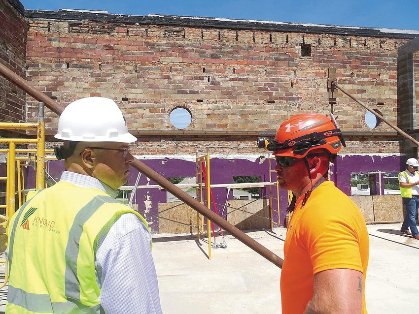 Developer Eric Hanna (left) speaks to a contractor on the roof of the former Temple Club in Old Town.