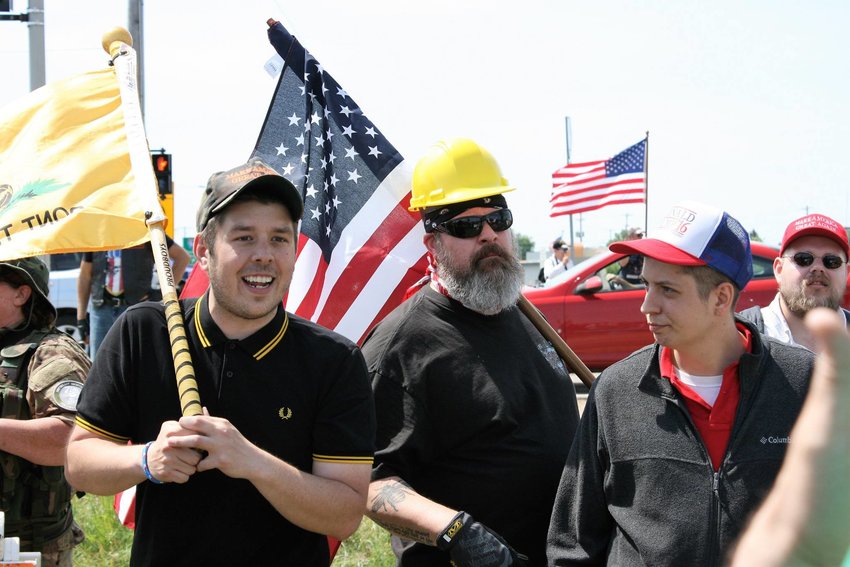 An unidentified member of the Proud Boys (left) in the group's trademark black and yellow polo shirt protests an alleged threat of Sharia law taking over the American judicial system on June 10, 2017. 