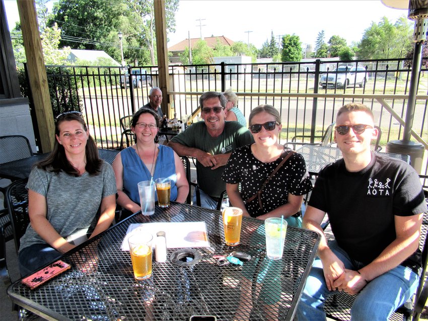 It’s “that simple feeling of connection: says Rawley Van Fossen (last on right) about what attracts him and his coworkers to Harry’s Place, where they convene for Happy Hour almost every Friday. (From left) Amanda Mussell, LeighAnna Beach, Jim Heinowski and Emma Henry. 