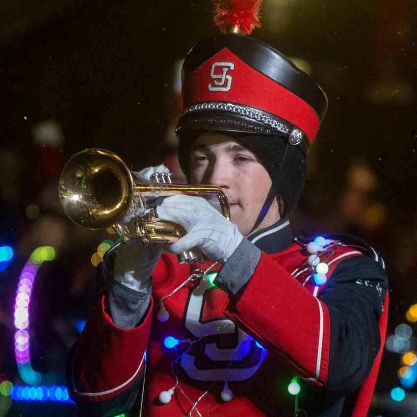 The Saint Johns High School Marching Band strung Christmas lights on instruments and themselves for the parade.