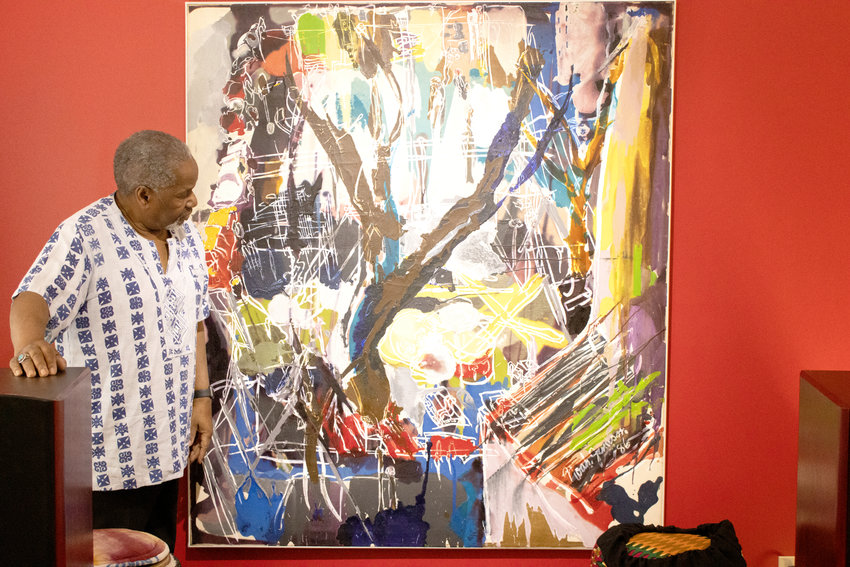 Eugene Cain shows off “The Rite of Spring,” by longtime friend and Black artist Noah Jemison. Photo: Taylor Blair for City Pulse