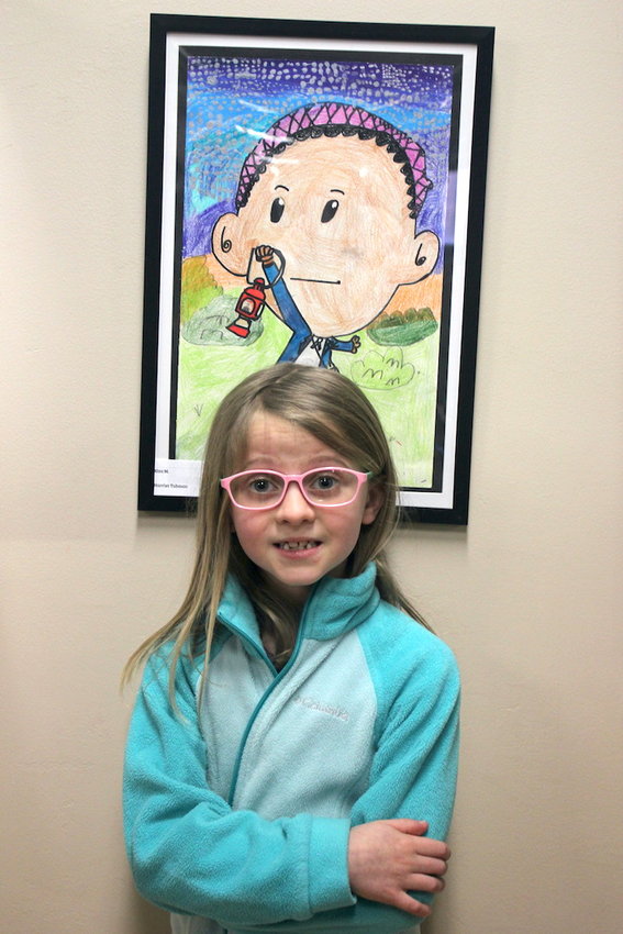 Donley Elementary student Emily Tobin (who is standing with someone else's piece) was thrilled to have her art displayed at Impression 5.