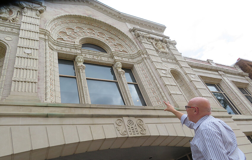 Gentilozzi pointing out details on the exterior of the historic Atrium Building, on Washington Square. Once the home of the Strand and Michigan theaters, the movie auditorium was torn down, but in the 1980s Gentilozzi Real Estate restored much of the interior, which is primarily offices.
