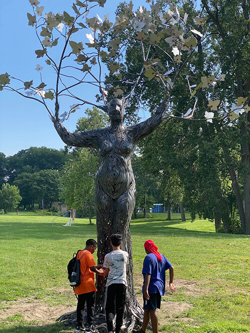 Youth check out “Mother Tree,” by St. Johns artist Ivan Iler, a 40-foot-high metal sculpture that was installed at Hunter Park in August.