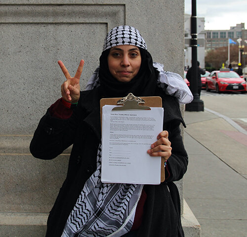 MSU grad student Mona Eldahshoury holds her media release forms at Union Station, preparing to recruit protesters to read a series of monologues written by Palestinian youth. 