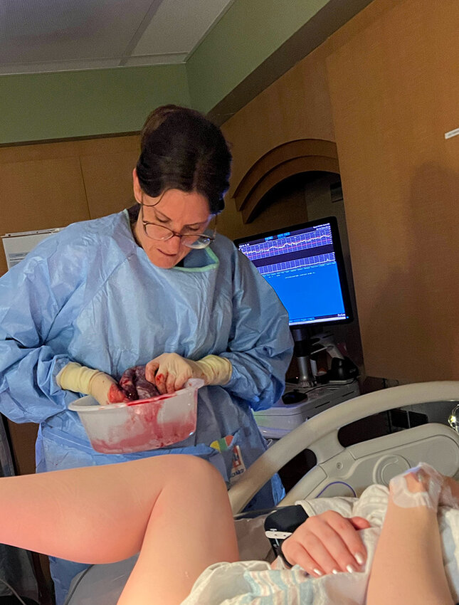 At Kendra Ouillette’s request, Dr. Renee Stevens shows her the placenta and educates her about the different parts of the organ.