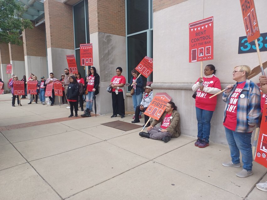 Rent Is Too Damn picketers line the sidewalk in front of the Lansing Center to advocate for renter’s rights during the first day of the Building Michigan Communities Conference on May 14.