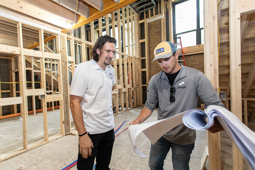 (Left) John Smith, property manager, DPMG Prime, and Luke Koerschner, project manager, Dymaxion Development looking over blueprints of apartments under construction in the old Holmes Street School.