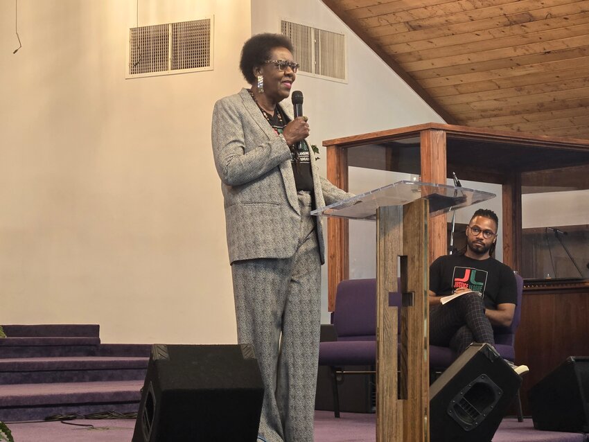 Justice League founder Willye Bryan (left) speaks as the organization's president, Prince Solace, looks on. The pair gave out out 10 scholarships to recent area high school graduates descended from enslaved Americans in a ceremony last Saturday.