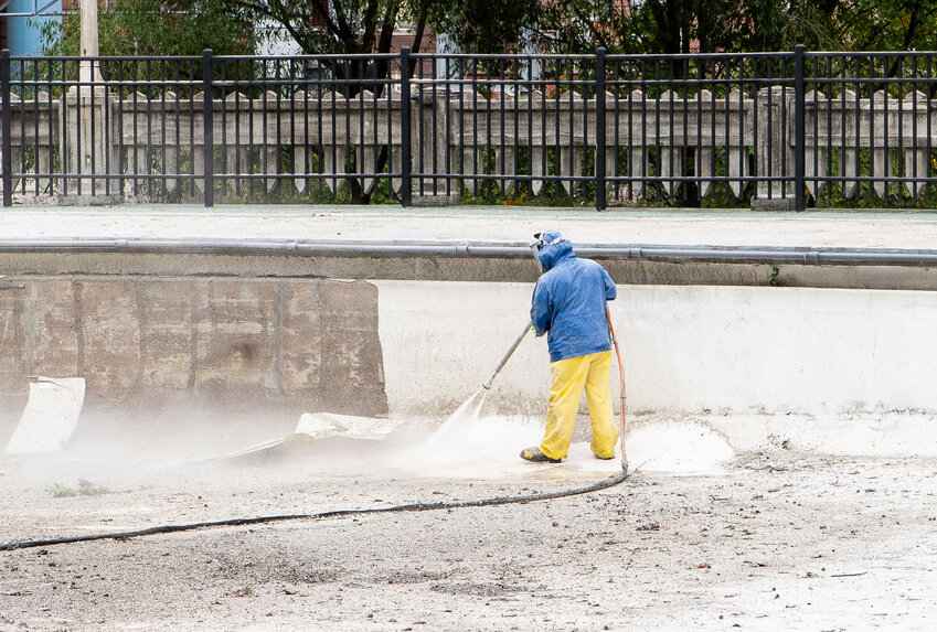 Workers clean the inside of Moores Park Pool to get it ready for the final legs of its restoration.