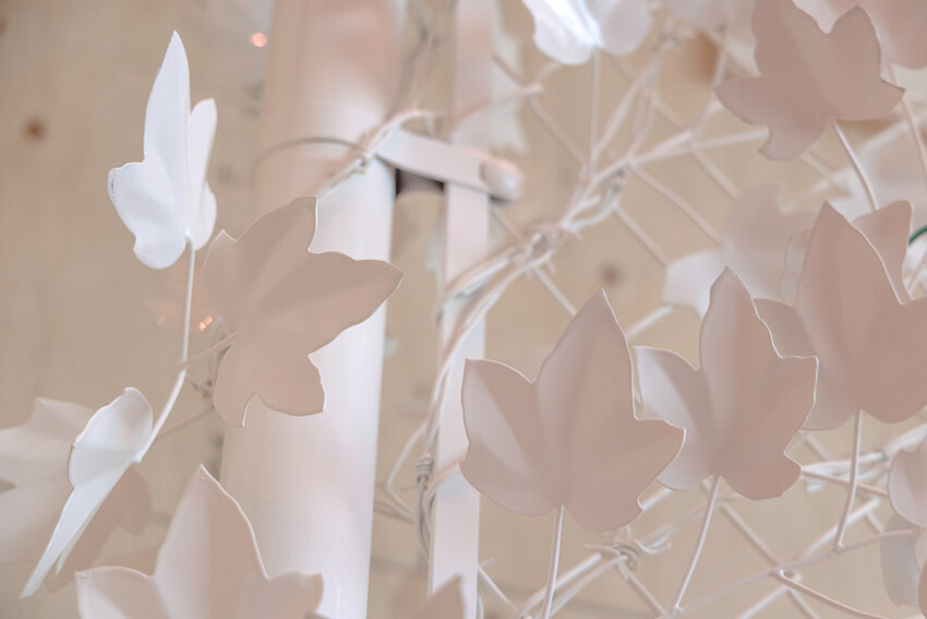 The 18-foot-tall fence featured in “Complex Dreams” is festooned with intertwining leaves, painstakingly die-cut from steel. Lush and lovely as the fence appears, razor wire lurks beneath the leaves. 