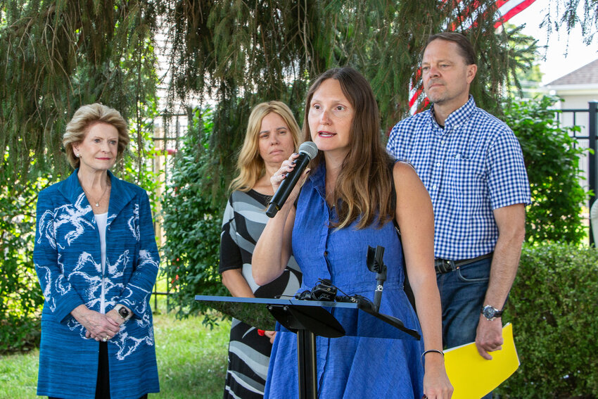 State Rep. Penelope Tsernoglou commends East Lansing residents Ann and George Siegle for installing solar panels on their home following remarks by U.S. Sen. Debbie Stabenow (left).